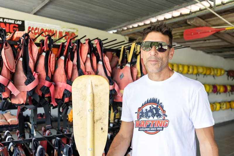 Istruttore di rafting sorridente davanti ai giubbotti salvagente