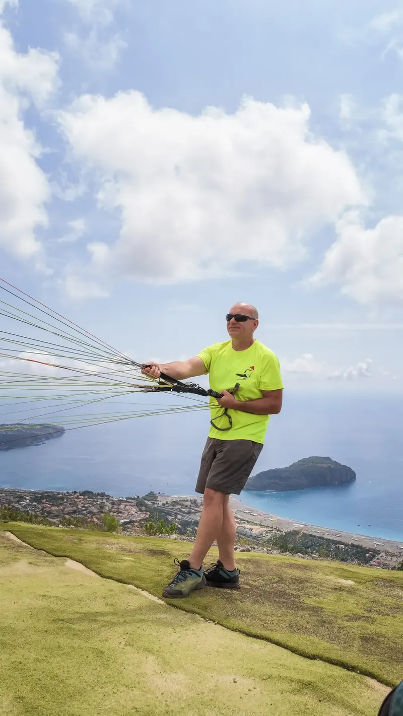 Parapendista che si prepara al decollo sopra la costa