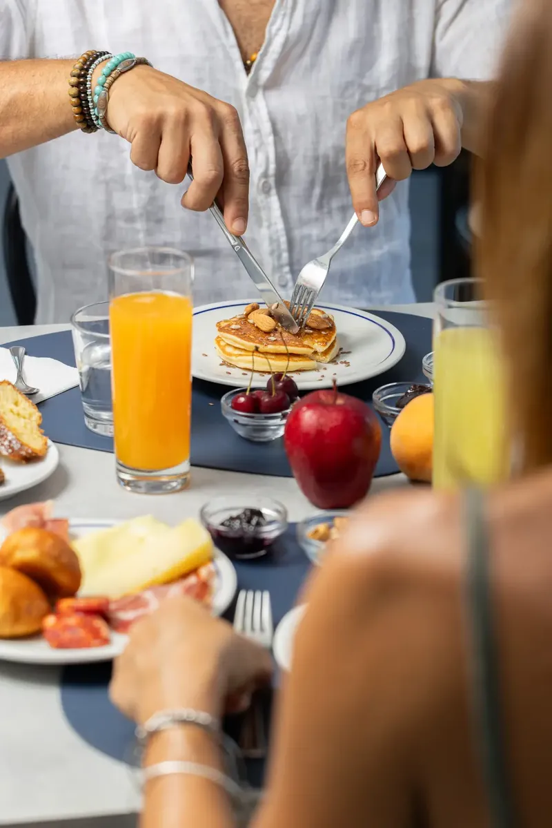 Ospiti a colazione con pancake, spremuta d'arancia e frutta